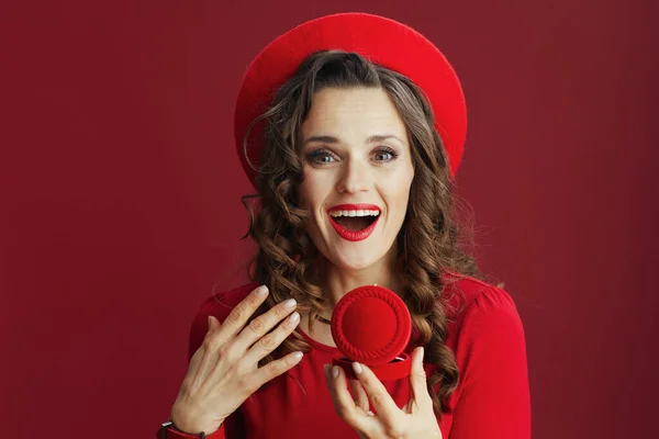 ハッピーバレンタイン エキサイティングなスタイリッシュな40歳の女性で赤いドレスとベレー帽の赤い背景にジュエリーボックス — ストック写真