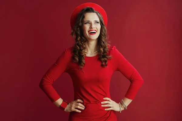 ハッピーバレンタイン 40歳のエレガントな笑顔赤いドレスに長い波状の髪を持つ女性とベレー帽は赤の背景に隔離された — ストック写真