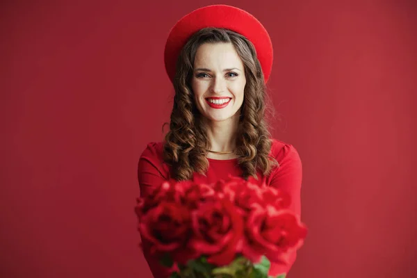 ハッピーバレンタイン 赤いドレスを着た40歳のエレガントな女性と赤いバラが赤いバラで隔離されたベレー帽 — ストック写真