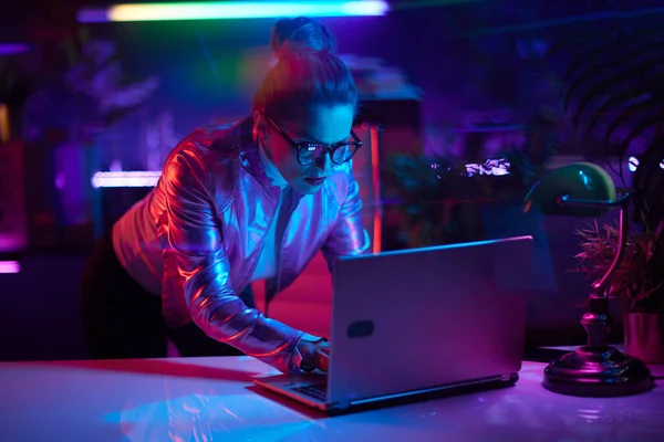 未来的な概念を嫌悪するネオン 現代のオフィスにノートパソコンを持つガラスの流行の女性 — ストック写真