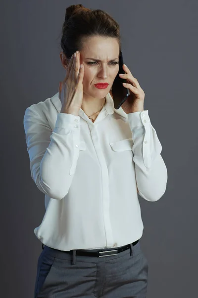 Zestresowana Stylowa Kobieta Pracownik Białej Bluzce Rozmawia Smartfonie Odizolowany Szary — Zdjęcie stockowe