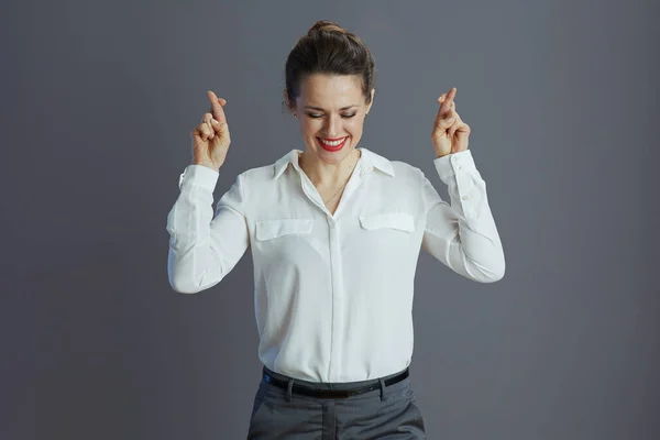 Счастливая Стильная Сотрудница Белой Блузке Скрещенными Пальцами Сером Фоне — стоковое фото