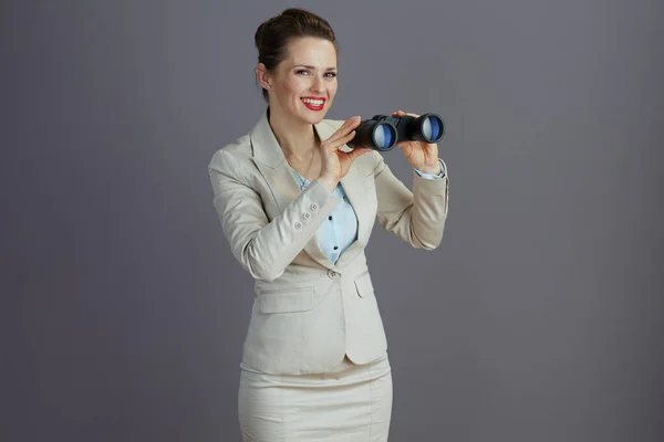 Smiling Trendy Female Employee Light Business Suit Binoculars Isolated Gray — Stock Photo, Image