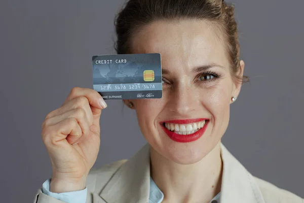 Portrét Usmívající Módní Pracovnice Lehkém Obleku Kreditní Kartou Izolované Šedém — Stock fotografie