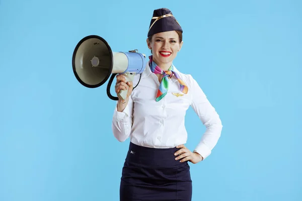 带扩音器的蓝色背景下优雅优雅的女空服员 — 图库照片