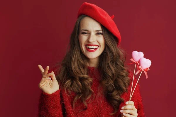 ハッピーバレンタイン 幸せな流行の女性とともに長い波状の髪で赤いセーターとベレー帽と心に棒 — ストック写真