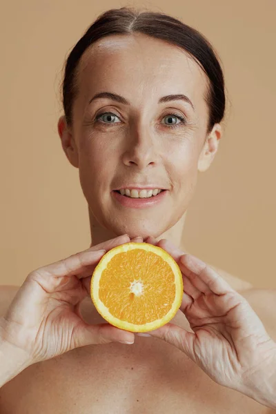 幸せな現代的な中年女性の肖像画でオレンジ絶縁上ベージュ — ストック写真