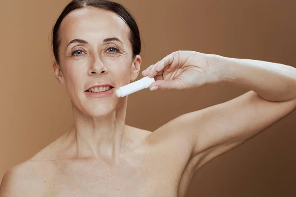 Moderne Frau Mit Hygienischem Lippenstift Auf Beigem Hintergrund — Stockfoto