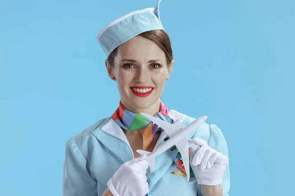 穿着蓝色制服 有一架小飞机的优雅优雅的女乘务员 — 图库照片