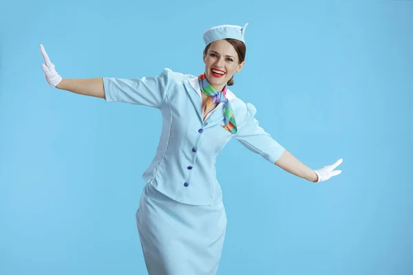 Glückliche Stylische Flugbegleiterin Vor Blauem Hintergrund Blauer Uniform Mit Ausgestreckten — Stockfoto