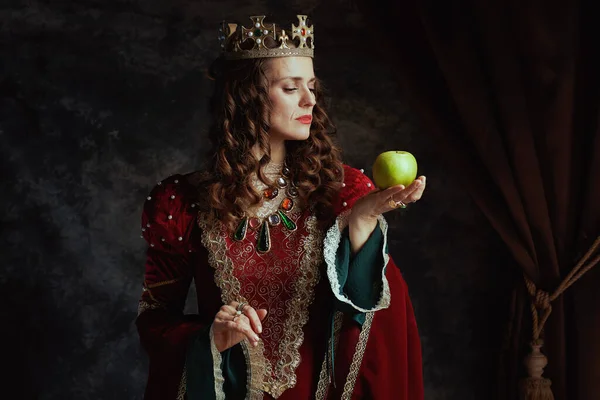 Středověká Královna Červených Šatech Zeleným Jablkem Korunou Tmavém Šedém Pozadí — Stock fotografie