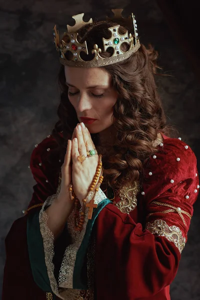 Middeleeuwse Koningin Rode Jurk Met Rozenkrans Kroon Bidden Donkergrijze Achtergrond — Stockfoto