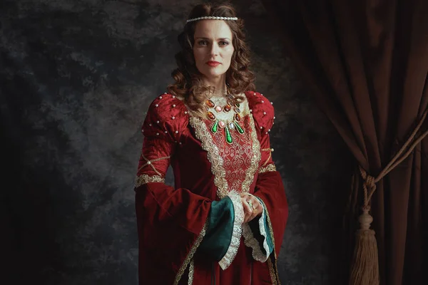 穿着深灰色背景红色衣服的中世纪女王 — 图库照片