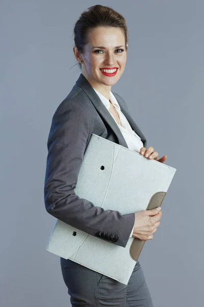 快乐时尚40岁的小企业主女人穿着灰色西装 夹在灰色的文件夹里 — 图库照片