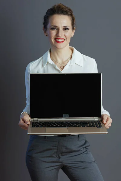 Gri Arka Planda Dizüstü Bilgisayar Ekranı Gösteren Beyaz Bluzlu Mutlu — Stok fotoğraf