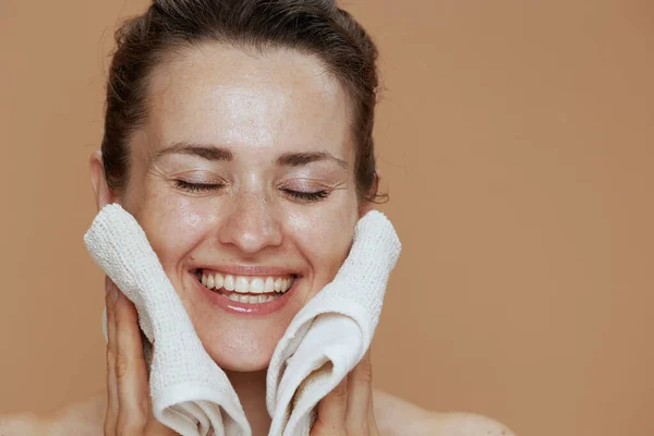 ベージュ地にタオル洗顔顔が孤立した幸せな現代女性 — ストック写真
