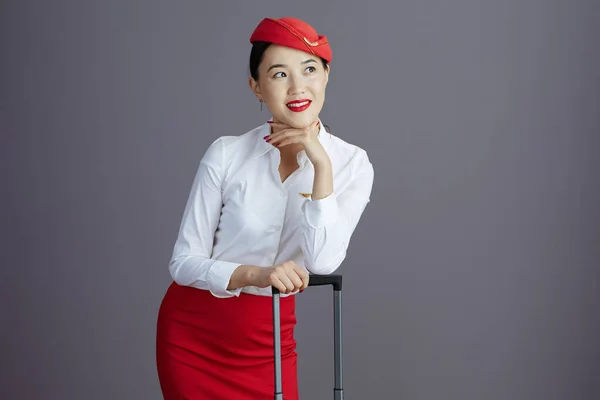 Zamyślony Elegancki Azjatycki Kobieta Stewardessa Czerwony Spódnica Kapelusz Mundur Torba — Zdjęcie stockowe