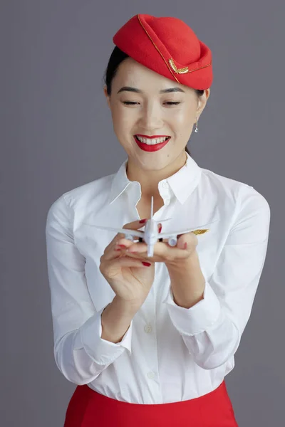 Uśmiechnięta Elegancka Azjatycka Stewardessa Czerwonej Spódnicy Mundurze Kapelusza Małym Samolotem — Zdjęcie stockowe