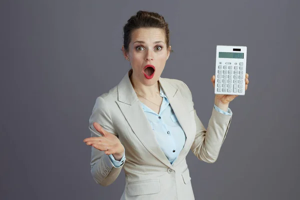 Zszokowany Elegancki Pracownik Średnim Wieku Kobieta Lekkim Garniturze Biznesowym Kalkulatorem — Zdjęcie stockowe