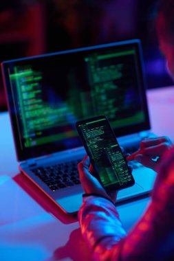 Modern ofisteki hackerların siber saldırılarına karşı dizüstü bilgisayarı ve akıllı telefonu olan modern iş kadınlarının arkasında görüldü..