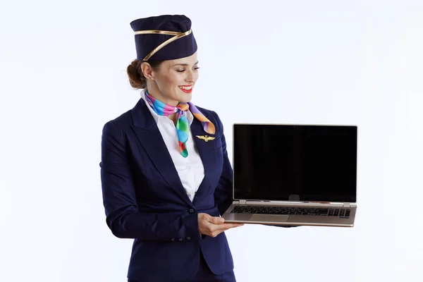 Leende Elegant Kvinnlig Luftvärdinna Mot Vit Bakgrund Uniform Visar Laptop — Stockfoto