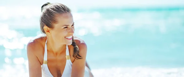 Mujer Joven Sonriente Sentada Orilla Del Mar Mirando Distancia — Foto de Stock