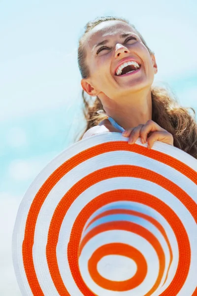 穿着泳衣 戴着海滩帽的快乐的年轻女人抬头看复印空间 — 图库照片