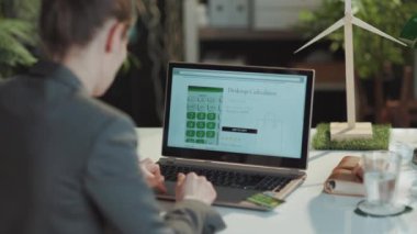 Modern ofisteki e-ticaret sitesinde bilgisayar ve kredi kartı ile online alışveriş yapan modern bir kadının arkasında görüldü..