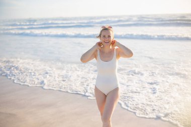 happy elegant female in white beachwear at the beach relaxing.