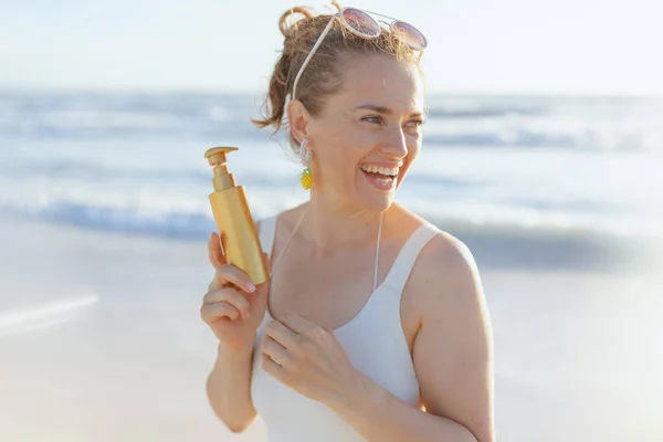 Sorrindo Elegante Mulher Meia Idade Maiô Branco Praia Aplicando Spf — Fotografia de Stock