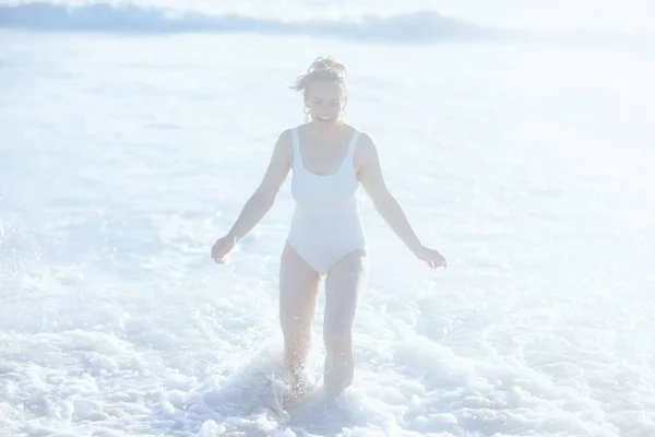 Gülümseyen Beyaz Mayo Giymiş Modern Bir Kadın Sahilde Eğleniyor — Stok fotoğraf