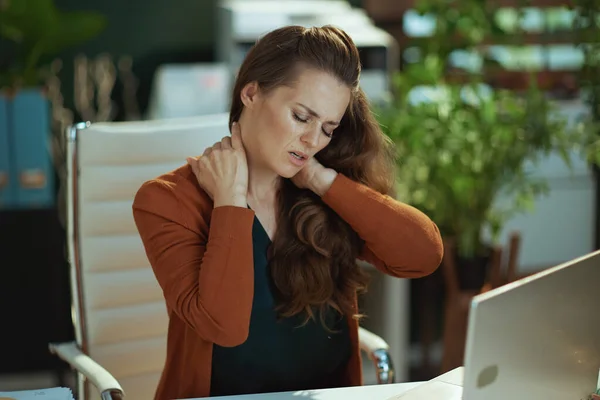 在现代的绿色办公室里 强调时髦的小企业主女人脖子上的疼痛 — 图库照片