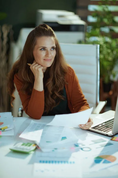 現代の緑のオフィスで書類を扱う流行の中小企業経営者の女性を笑顔 — ストック写真