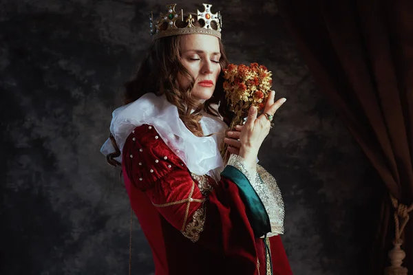 Kurumuş Çiçekli Kırmızı Elbiseli Ortaçağ Kraliçesi Koyu Gri Arka Planda — Stok fotoğraf