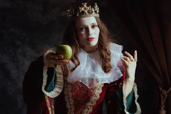 穿着红色衣服的中世纪女王 绿色苹果 白领和深灰色背景的皇冠 — 图库照片