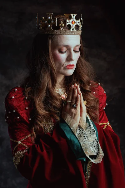 Kırmızı Elbiseli Ortaçağ Kraliçesi Koyu Gri Arka Planda Dua Ediyor — Stok fotoğraf