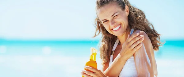 Mujer Joven Sonriente Aplicando Crema Protector Solar Playa —  Fotos de Stock