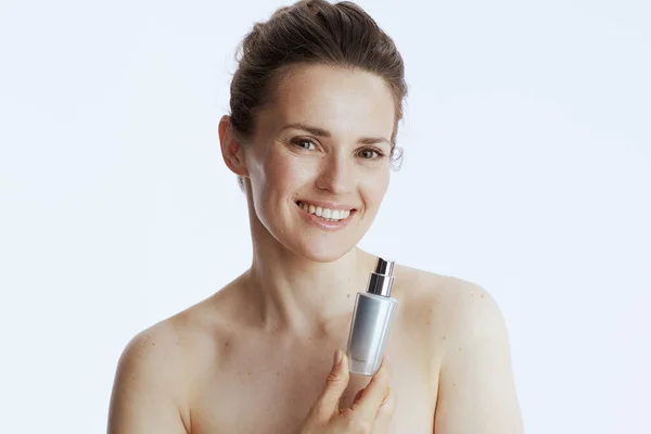 笑容满面的中年妇女与白色背景的化妆品瓶 — 图库照片