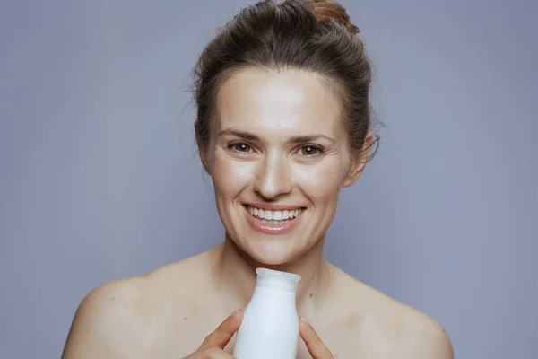 Gülümseyen Yaşındaki Modern Kadın Mavi Arka Planda Kozmetik Krem Kavanozuyla — Stok fotoğraf