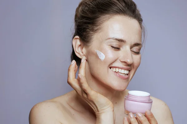 Glimlachende Jonge Vrouw Met Cosmetische Crème Pot Blauwe Achtergrond — Stockfoto