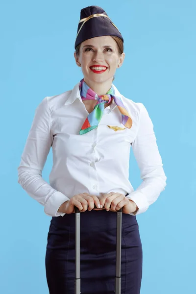 Glimlachende Elegante Vrouwelijke Stewardess Geïsoleerd Blauwe Achtergrond Uniform Met Reistas — Stockfoto