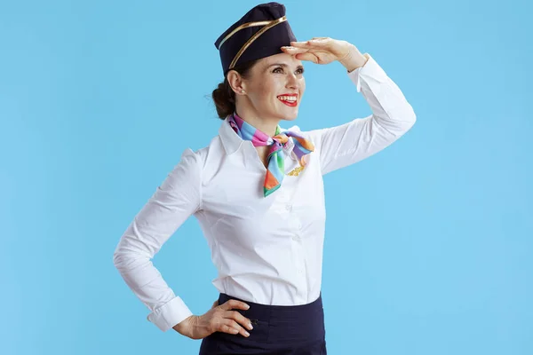 穿着蓝色背景制服的现代女乘务员微笑着 遥望远方 — 图库照片
