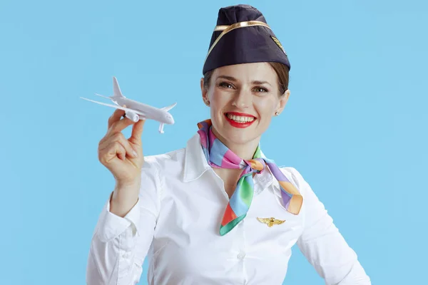 快乐的现代空姐 蓝色背景 身穿制服 有一架小飞机 — 图库照片