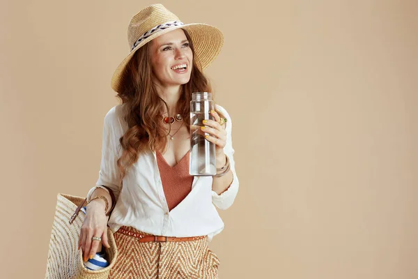 海滩度假 穿着白色衬衫和短裤的快乐时尚女性 与水瓶 草袋和草帽隔离在一起 — 图库照片