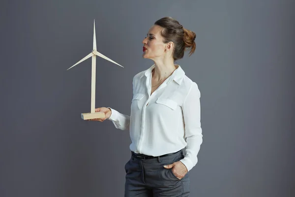 happy elegant middle aged business woman in white blouse with windmill isolated on grey.