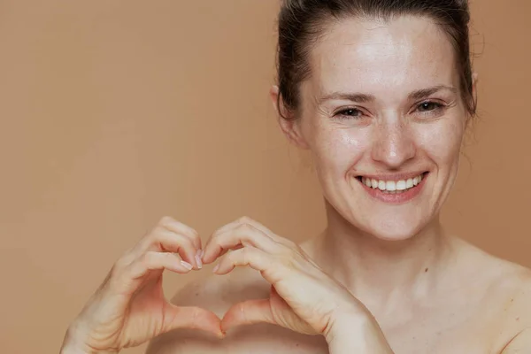 Feliz Mulher Meia Idade Mostrando Mãos Forma Coração Fundo Bege — Fotografia de Stock