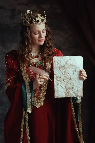 中古时代的女王 穿着红色衣服 头戴深灰色背景的羊皮纸和皇冠 — 图库照片