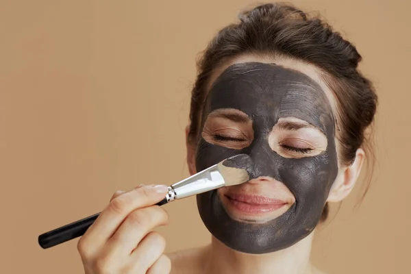Moderne Vrouw Met Borstel Cosmetische Masker Geïsoleerd Beige Achtergrond — Stockfoto