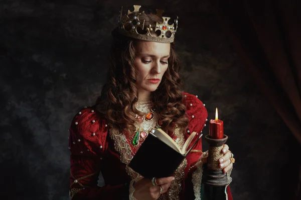 Średniowieczna Królowa Czerwonej Sukience Książką Świecą Koroną Ciemnoszarym Tle — Zdjęcie stockowe