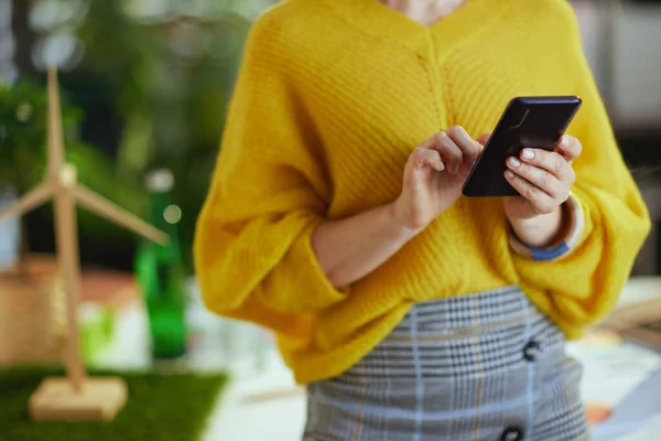 スマートフォンを使用して緑のオフィスで黄色のセーターの中小企業の所有者の女性の閉鎖 — ストック写真